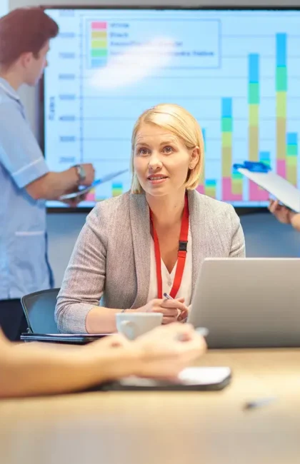 a mixed group of healthcare professional and business people meet around a conference table .
